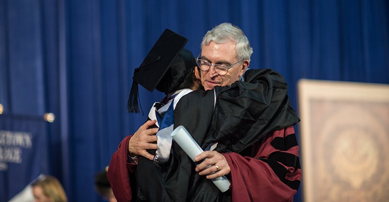 Dean Chester Gillis embraces a student at the 2016 Georgetown College Commencement ceremony.