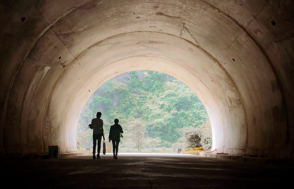 image of two people walking through a tunnel