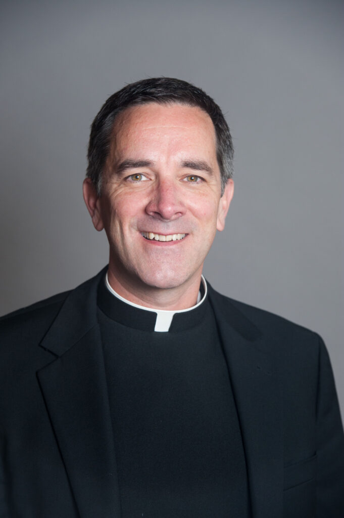 Headshot of Father David Collins on grey background