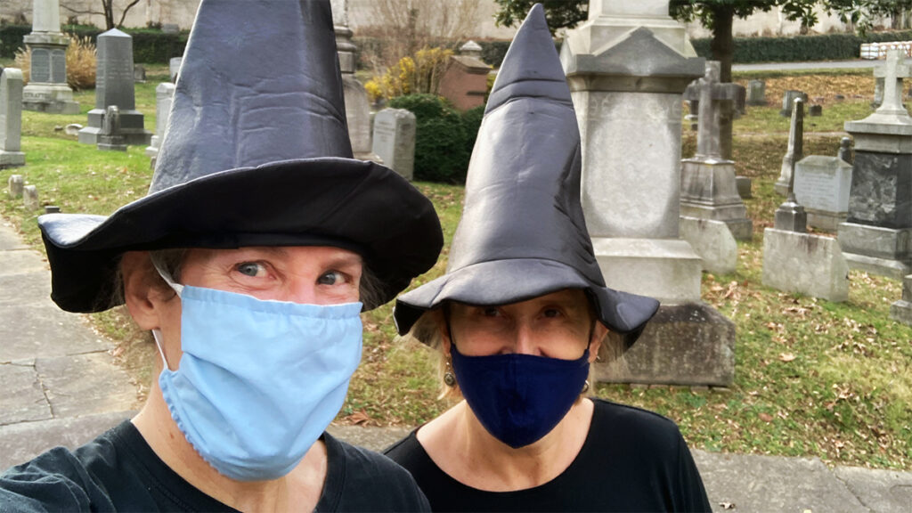 Games and Leonard wear masks and witch hats in a cemetery
