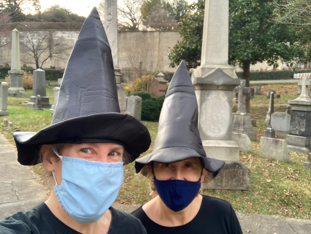 Games and Leonard wear masks and witch hats in a cemetary