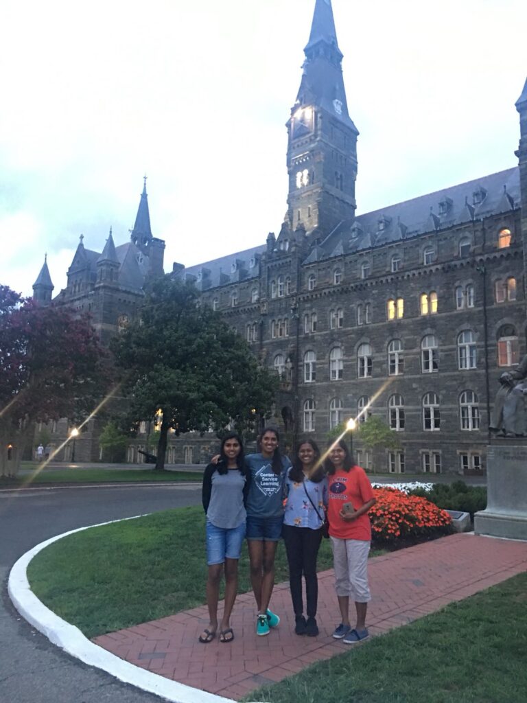 Dominic stands in front of Healy Hall with her mother and three sisters