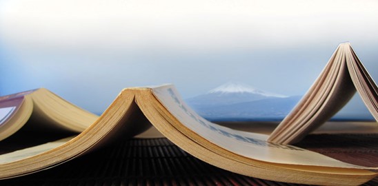 Photo of open books in front of a mountain