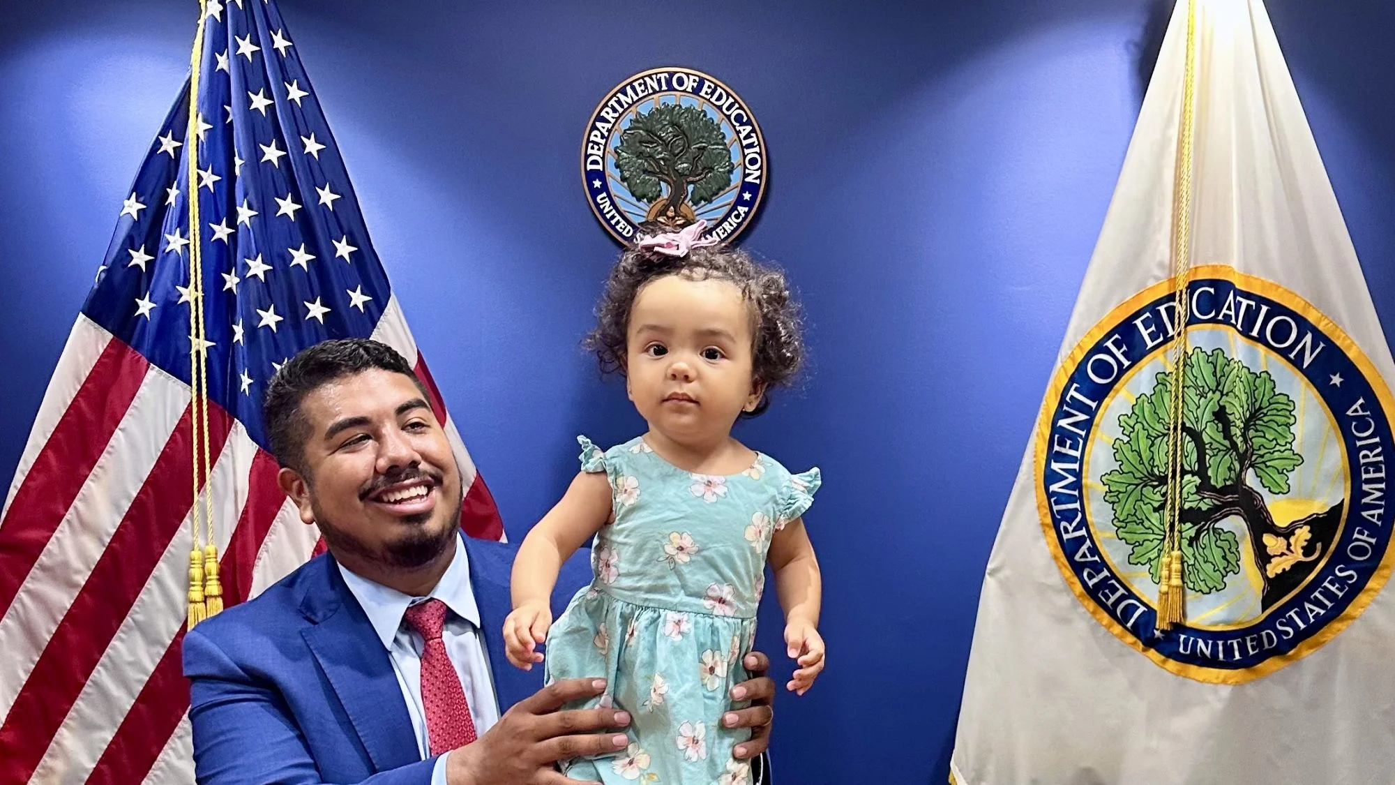 Adan Gonzalez (C'15) was holding his three-day-old daughter in front of the US and Dept. of Education flags