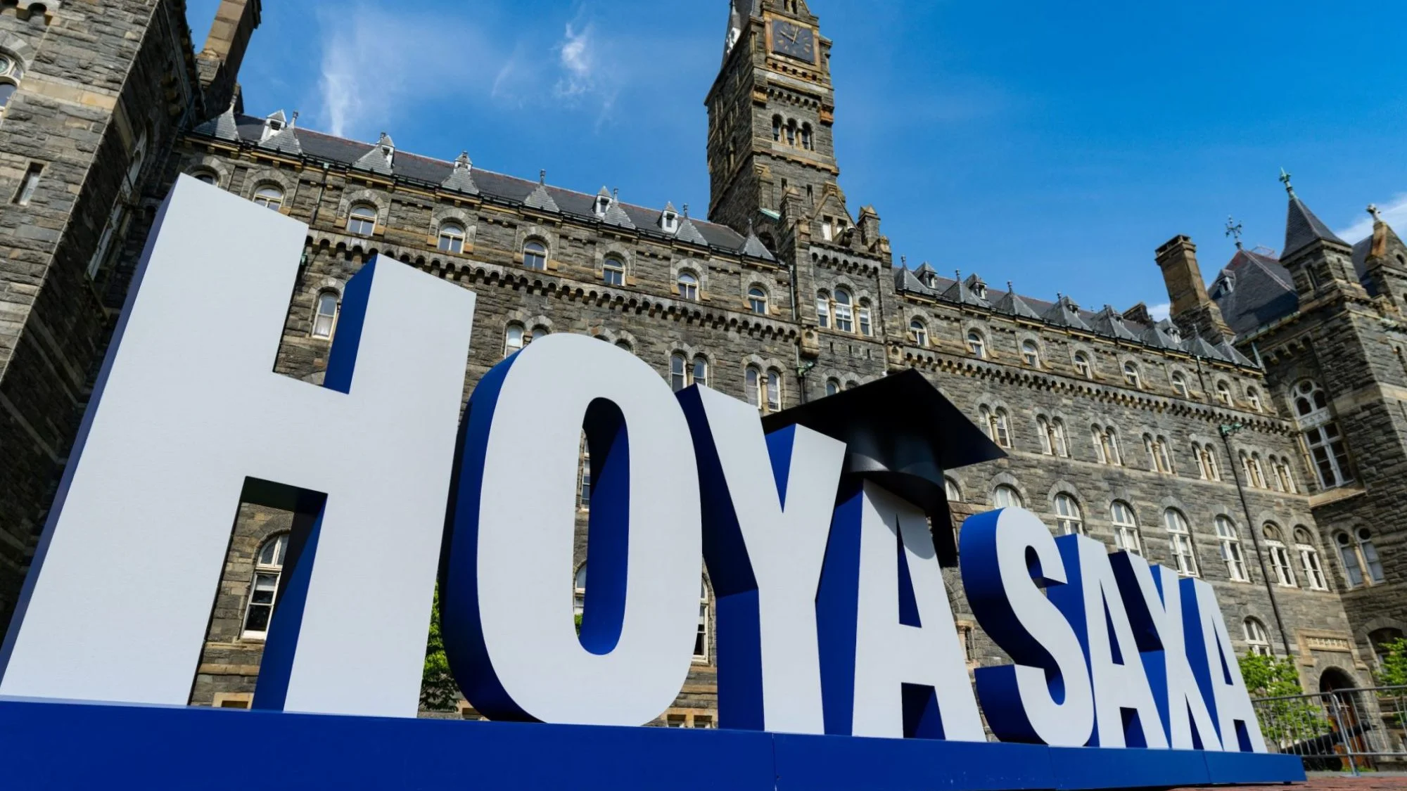 A large white sign reading Hoya Saxa rests on the ground in front of a gray stone building.