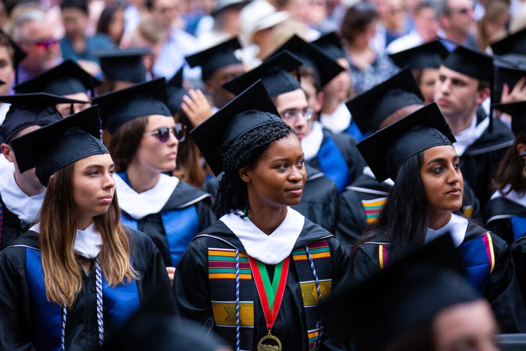 New graduates in cap and gown during the ceremony on Healy Lawn