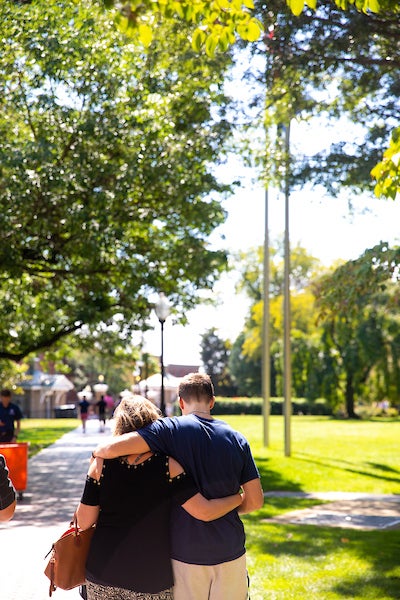 Mom and student walking across campus