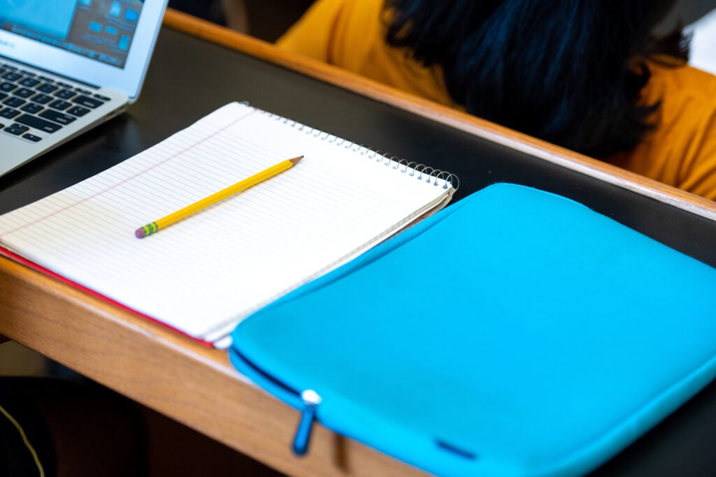 Notebook and laptop sleeve on a classroom desk