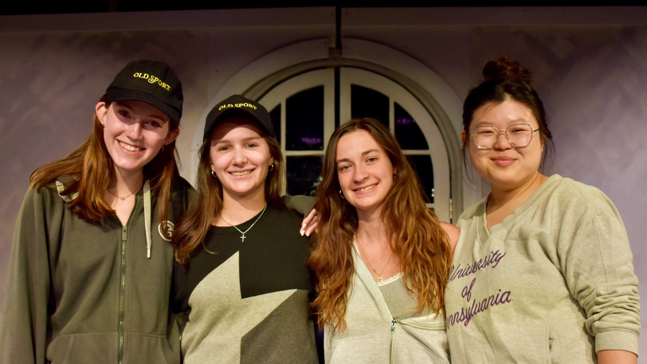 A group of four young women stand on a stage.