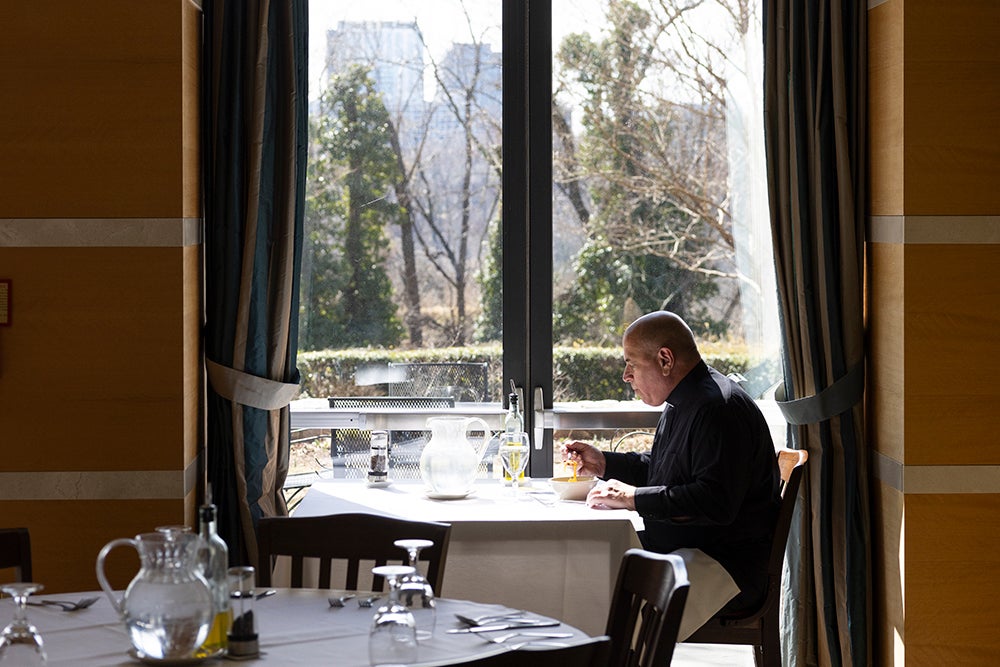 man sitting in dining room near window eating