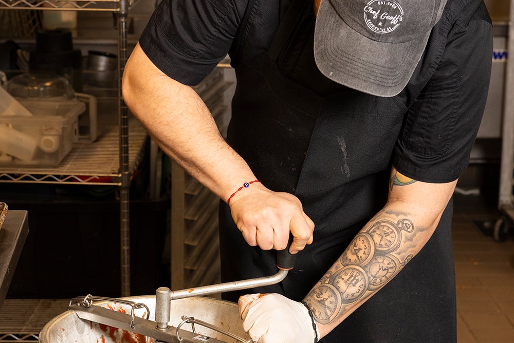 Chef Amilcar mills tomatoes for the day’s sauce