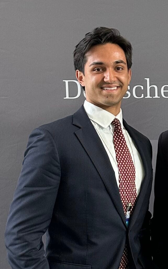 A man wearing a suit and smiling at the camera.