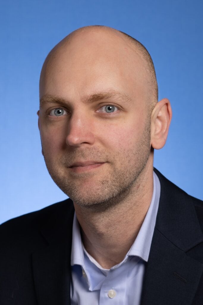 Headshot of a professor wearing a jacket and dress shirt