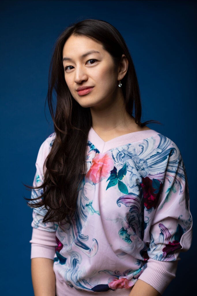 A professor wearing a floral shirt looking at the camera for a headshot.
