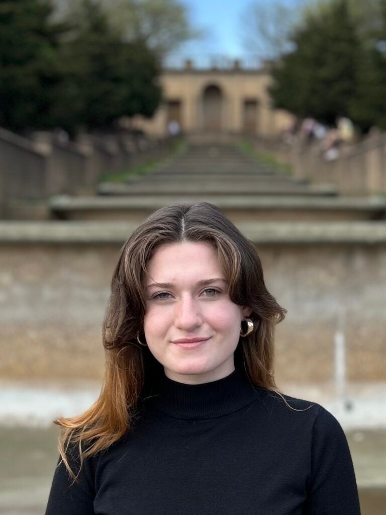 A woman wearing a black shirt smiling at camera.