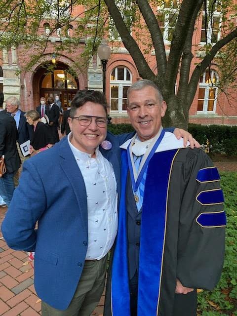 Two colleagues smiling together at Georgetown’s convocation in October 2021.
