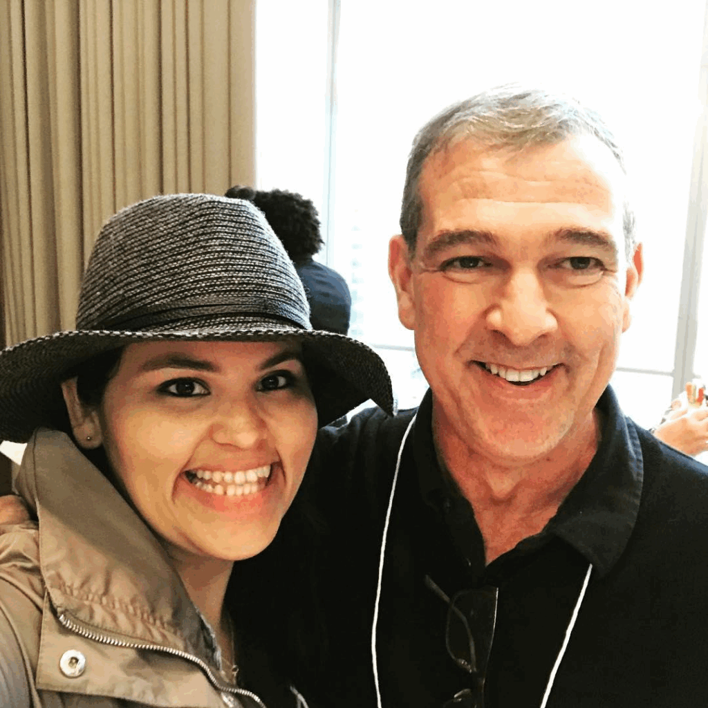 A professor and a former student standing together at a conference.