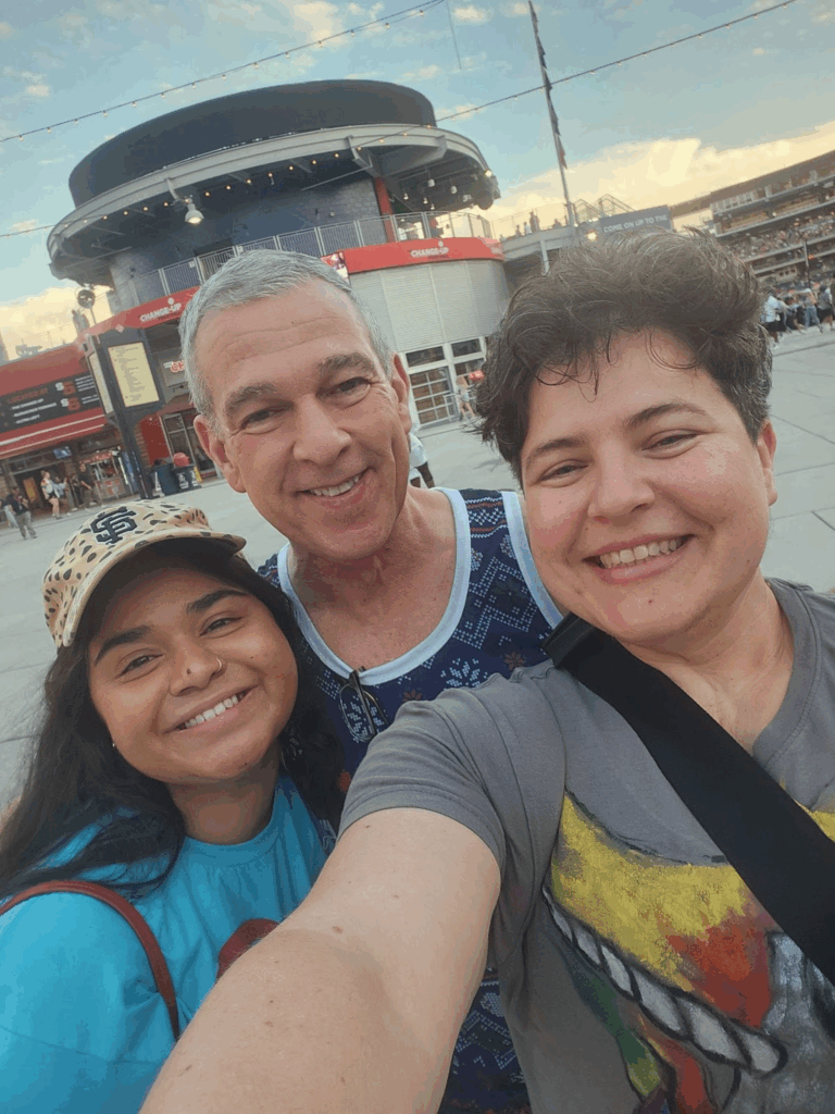 Three friends in a casual, outdoor setting at Nationals Park during the summer.
