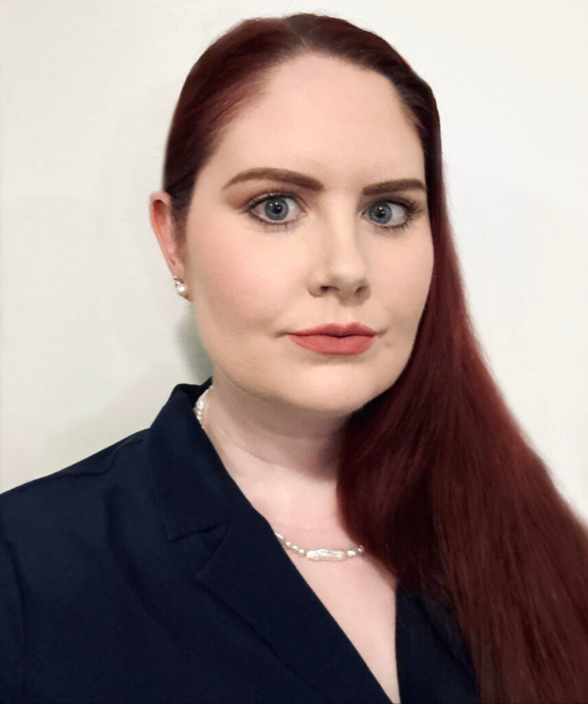 A woman wearing a blue jacket looking at the camera for a headshot.