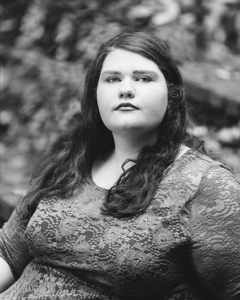 A black-and-white photo of a woman  looking into the camera for a portrait.