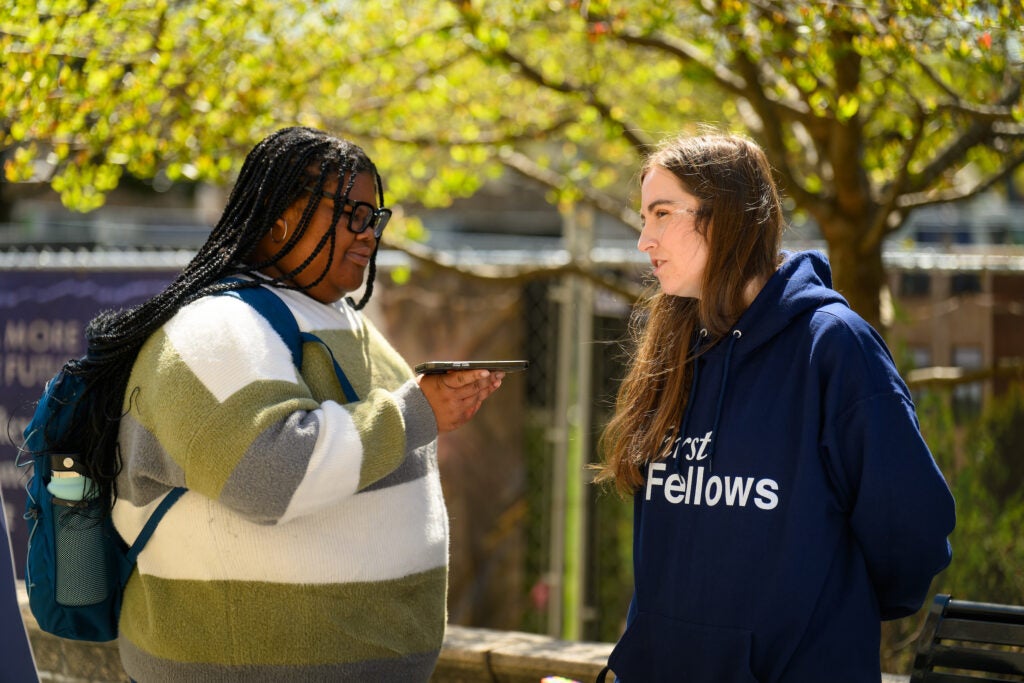 A Georgetown student and staff member having a conversation outside during a sunny day