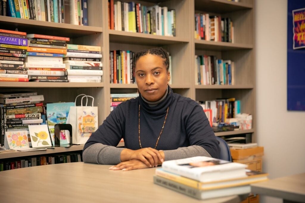 A Georgetown sociology professor sitting at a desk in front of a bookshelf full of books