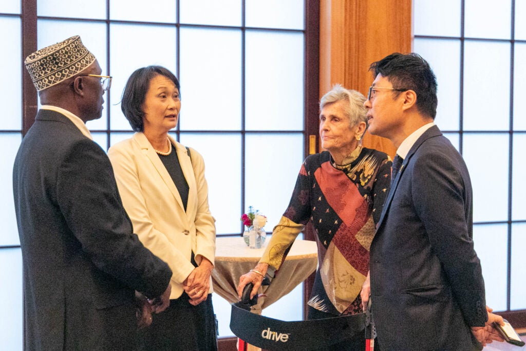 A professor, her husband, friends and colleagues talking during an award ceremony. 