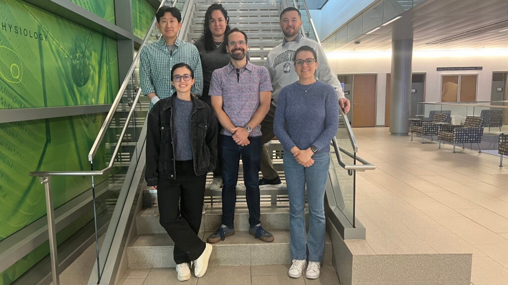 A group photo featuring a biology professor and colleagues from his lab.