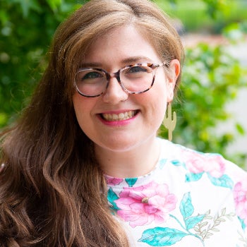 A program manager in a floral shirt smiling for a headshot