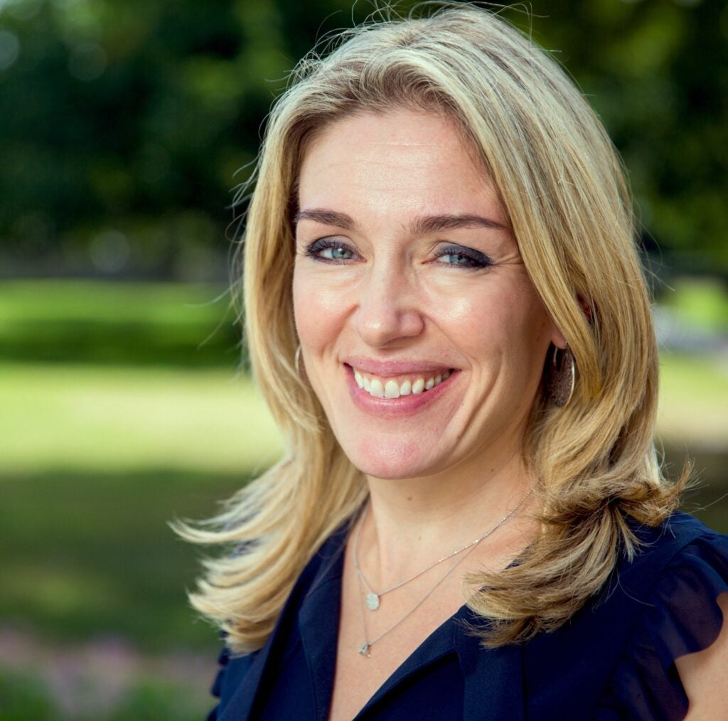 A psychology professor wearing a blue shirt smiling