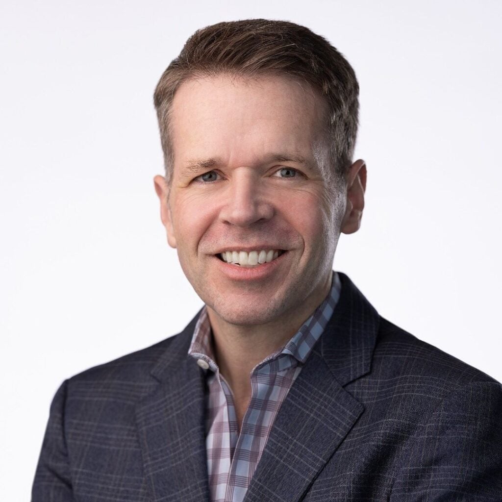 A professor of Classics smiling for a headshot