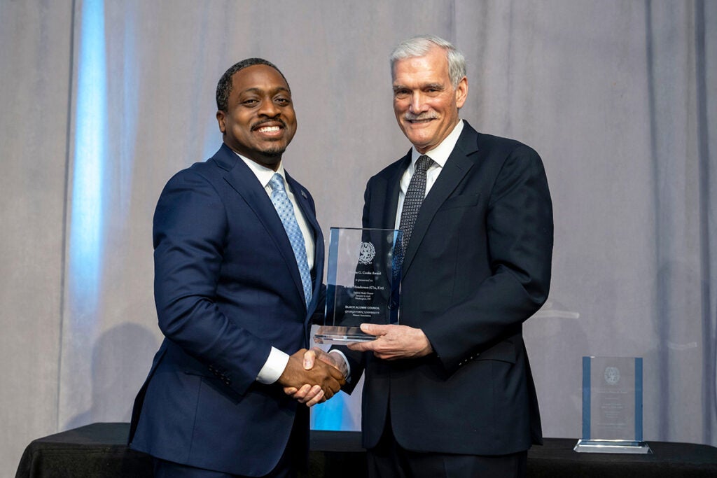 K'sean Henderson (C’12, L’18), left, is congratulated by Georgetown University Interim President Robert M. Groves