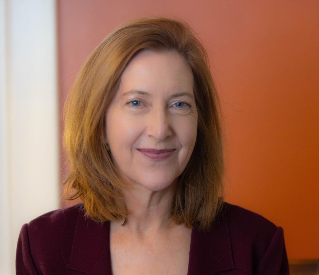 An English professor smiling for a headshot