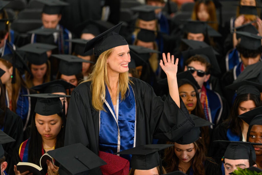 One student waving at the 2026 College of Arts and Sciences commencement