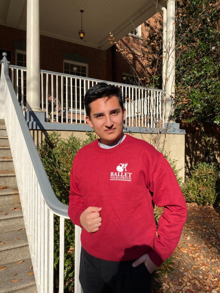 A student wearing a red sweatshirt posing 