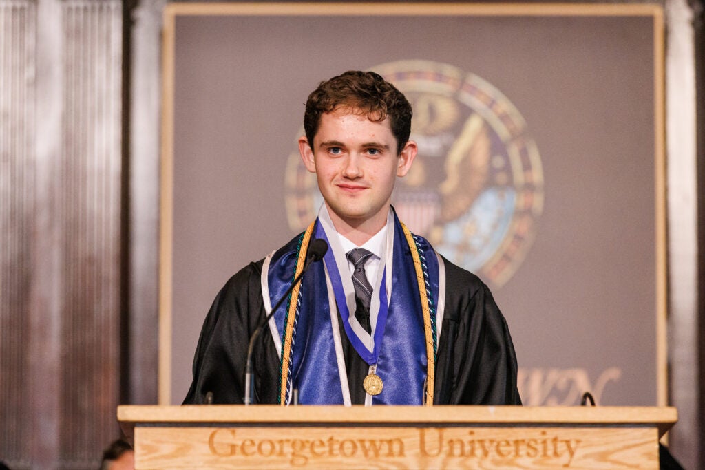A student standing at a podium before his speech