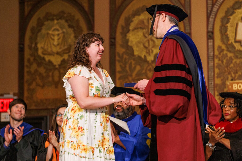 A student shaking hands with the dean of the College of Arts and Sciences