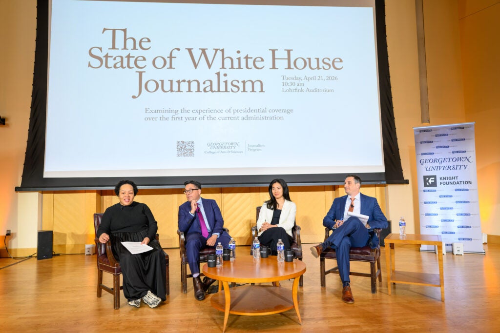 Panelists sitting on stage at Lohrfink Auditorium