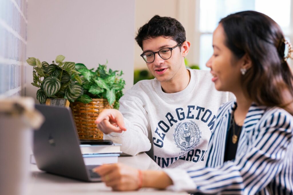 Students inGU apparel at a laptop