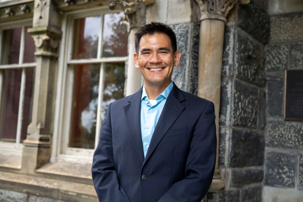 Portrait of a Georgetown University professor wearing a jacket and dress shirt smiling.
