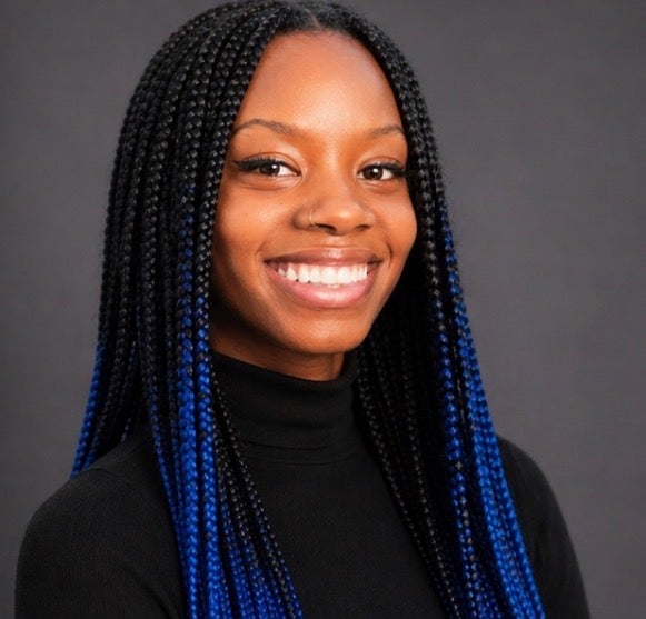 Headshot of a Georgetown University administrator smiling in front of a neutral background.