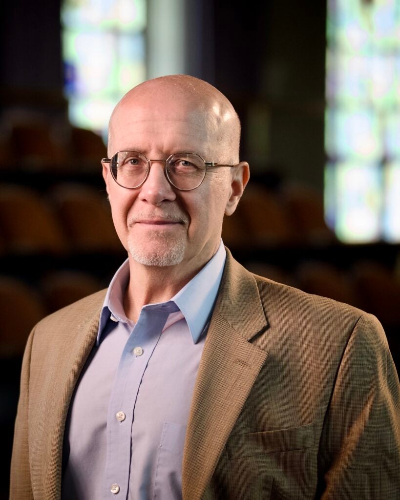Headshot of a Georgetown University visiting professor posing in front of a neutral background.