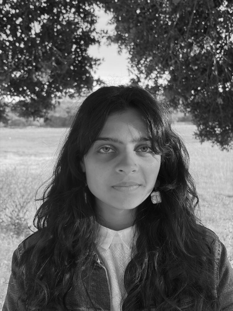 Black-and-white headshot of a Georgetown University professor standing in front of blurred background.
