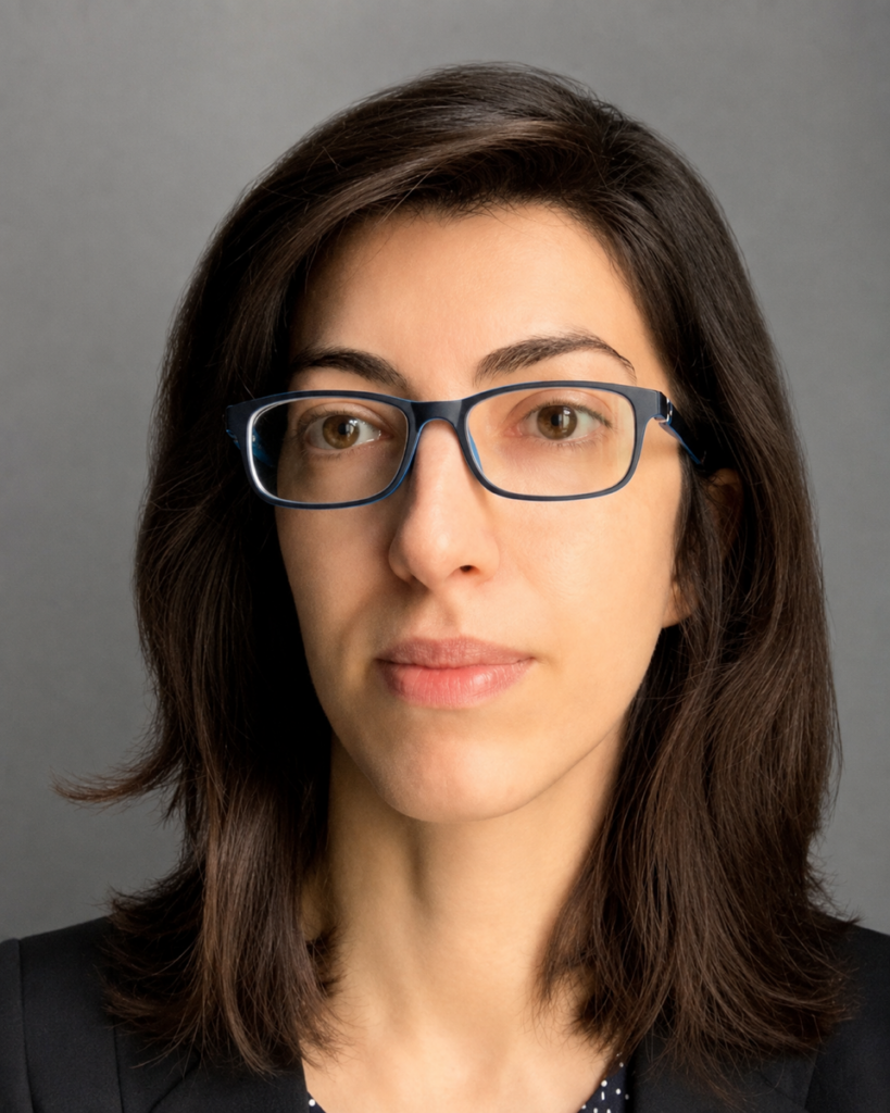 Headshot of a Georgetown University professor wearing glasses in front of a neutral background.