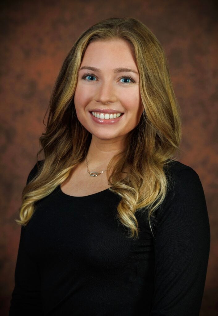 Headshot of a Georgetown University administrator smiling in front of a neutral background.
