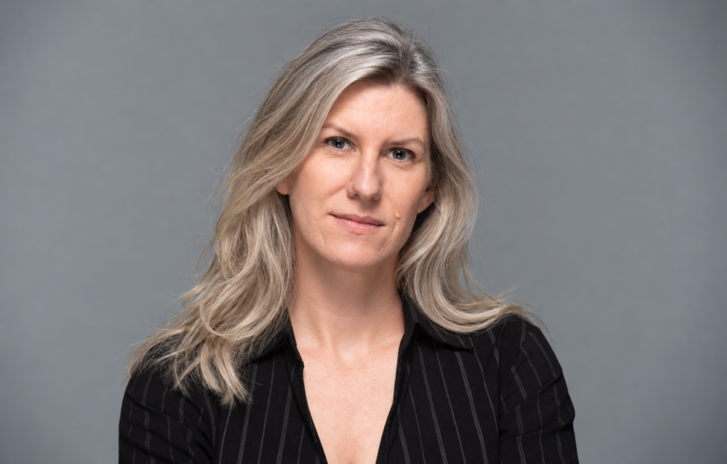 Headshot of a Georgetown University visiting professor posing in front of a neutral background.