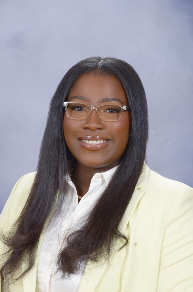 Headshot of a Georgetown University administrator smiling in front of a neutral background.