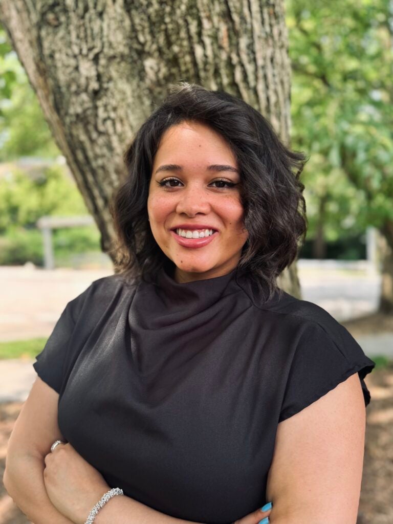 Headshot of a Georgetown University administrator smiling in front of a blurred background.