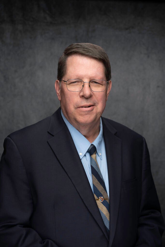 Headshot of a Georgetown University visiting professor an Jesuit priest posing in front of a neutral background.