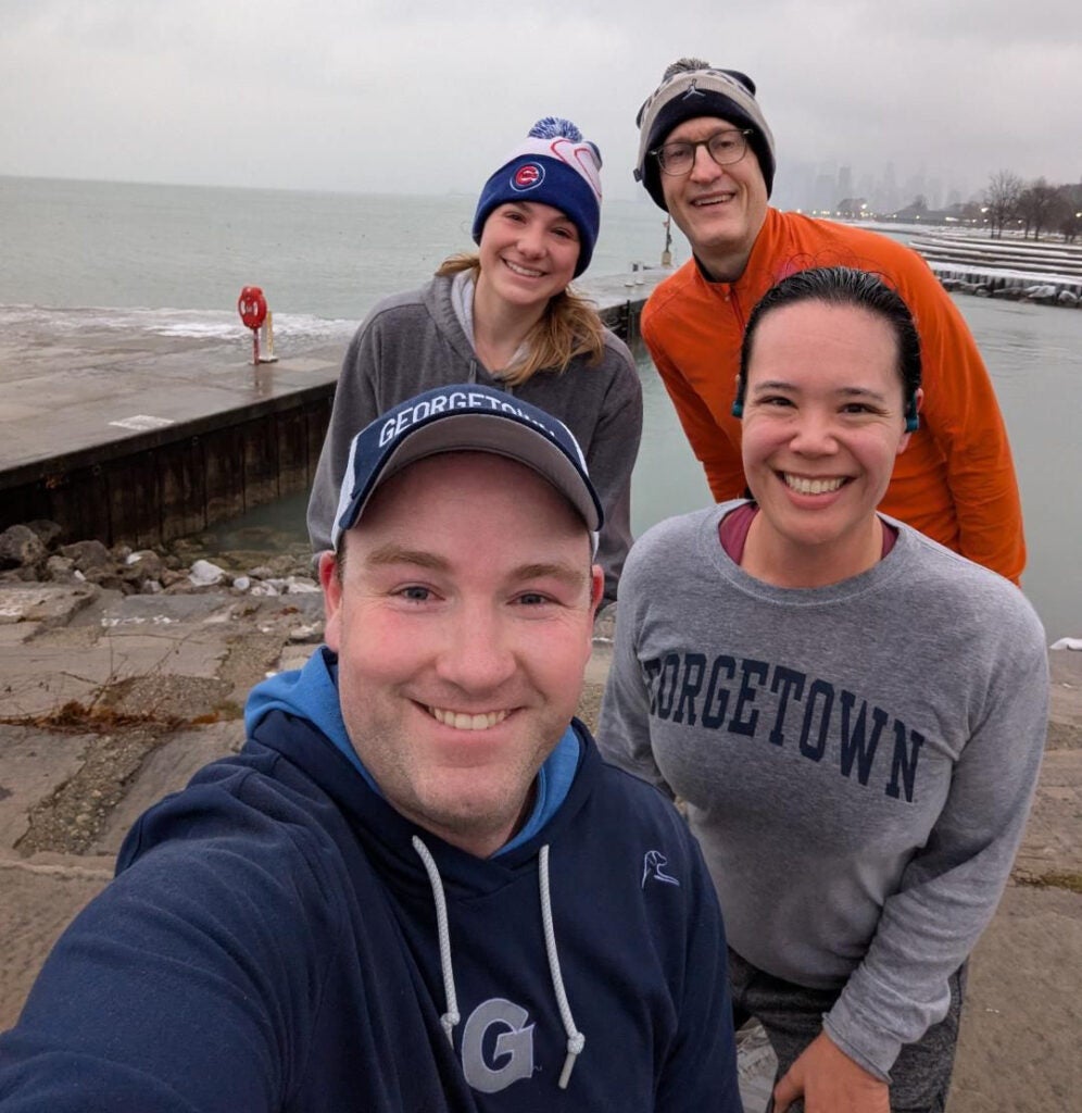 A group of four runners taking a selfie in Chicago during the winter.